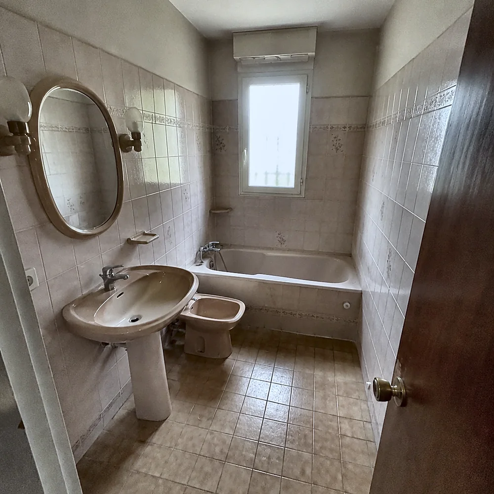 Baño antiguo con bañera y azulejo rosa antes de la reforma