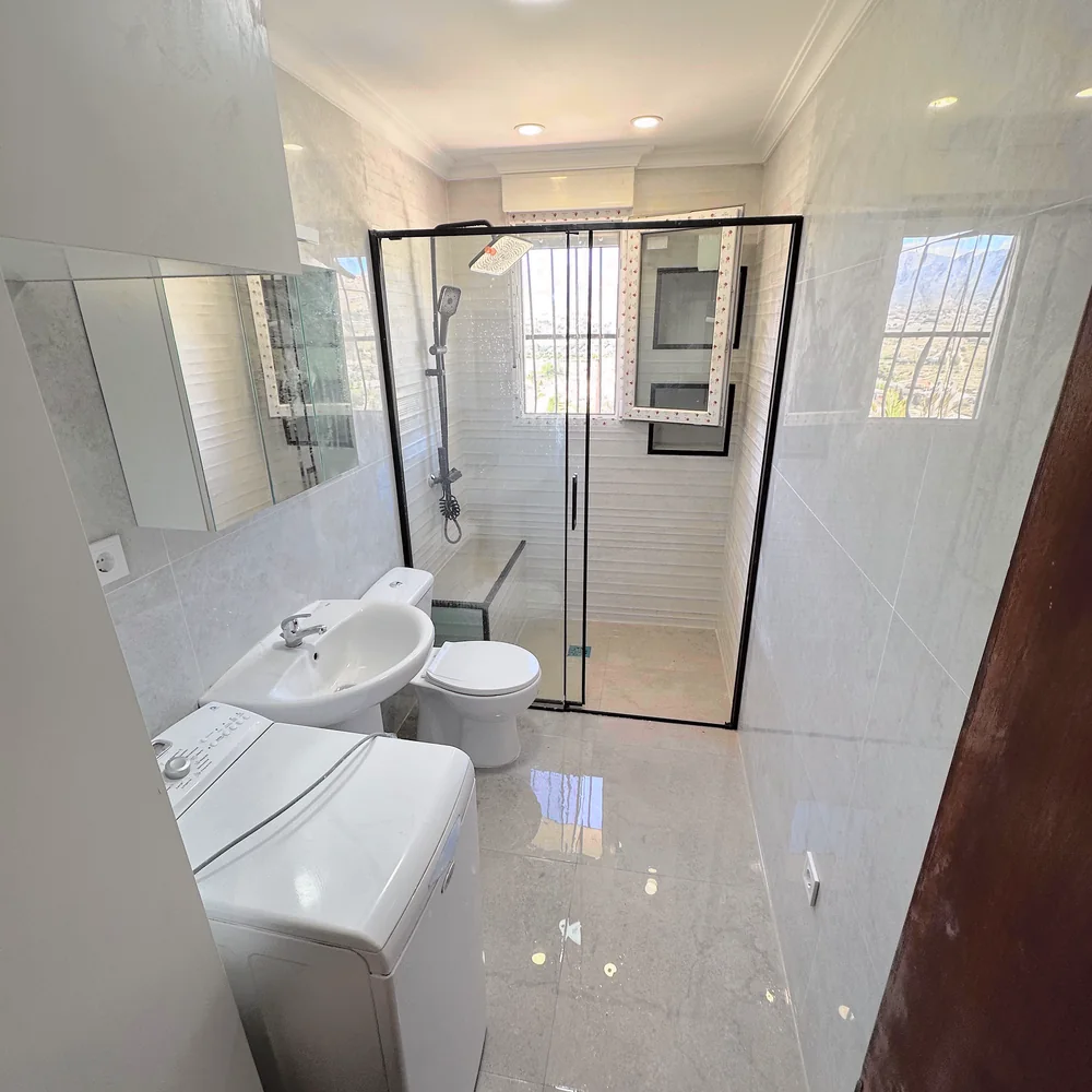El mismo baño reformado con ducha de mampara y revestimiento nuevo